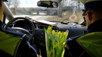 policjanci z tulipanami w radiowozie