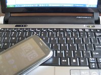 telefon komórkowy położony na klawiaturze laptopa