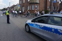 policjantka zabezpiecza przejazd rowerzystów