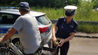 policjantka przypina odblask do bagażnika roweru