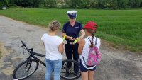 policjantka wręcza odblaski rowerzystce i jej córce