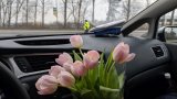 policjanci wręczają kwiaty z okazji Dnia Kobiet