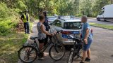 policjanci w rozmowie z parą rowerzystów przy radiowozie