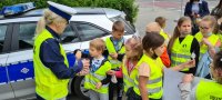 policjantka wręcza dzieciom lizaki