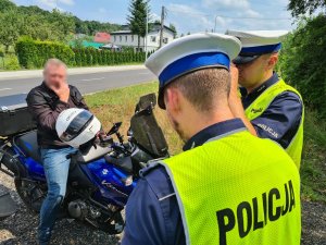 Policjanci ruchu drogowego podczas rozmowy z kierowcą motocykla