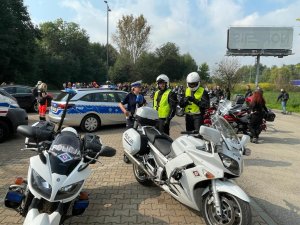 na pierwszym planie policyjne motocykle, w tle policjanci ruchu drogowego, radiowóz i uczestnicy zlotu