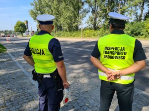 policjant ruchu drogowego i funkcjonariusz Inspekcji Transportu Drogowego obserwują ruch pojazdów