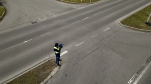 zdjęcie przedstawia policjanta kontrolującego prędkość pojazdów