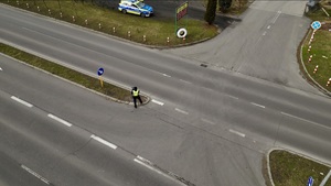 zdjęcie przedstawia policjanta kontrolującego prędkość pojazdów