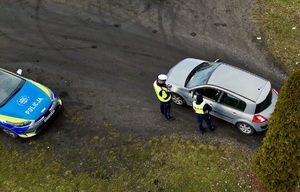 zdjęcie przedstawia policjanta kw trakcie kontroli drogowej