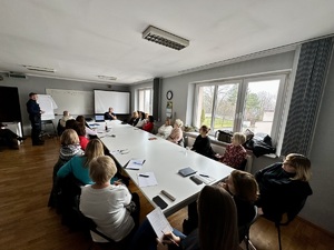 zdjęcie przedstawia widok sali w której siedzą zgromadzone osoby