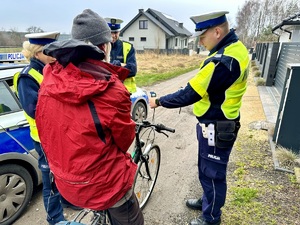 zdjęcie przedstawia policjantów w trakcie kontroli rowerzysty